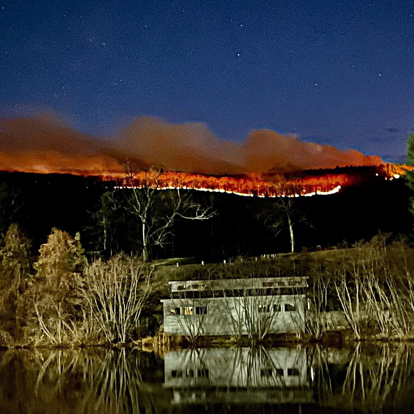 fire line on the mountain behind ski lodge at night
