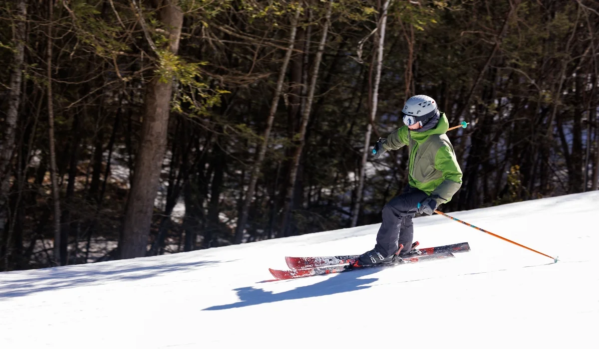 man in green jacket skiing