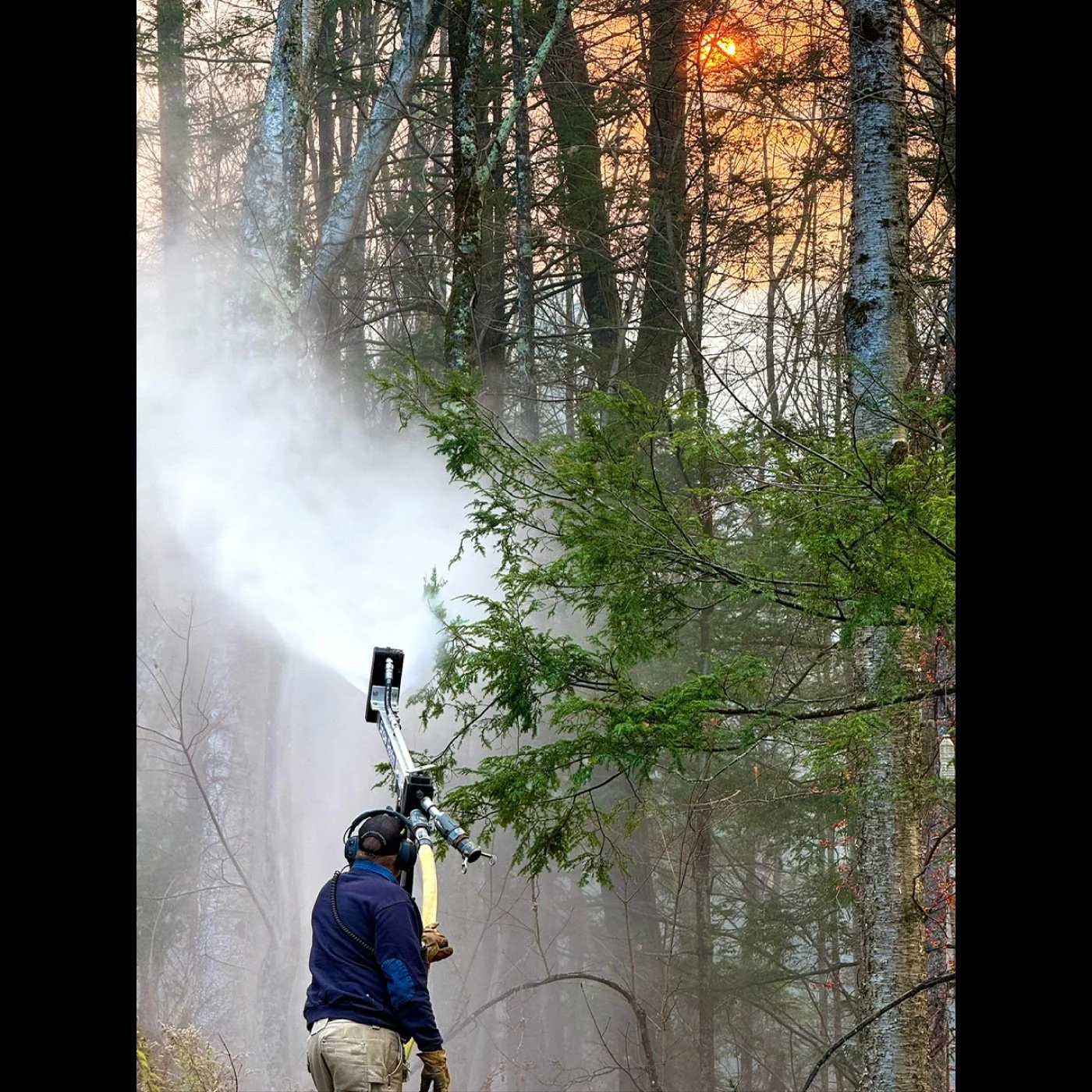 fire fighter using water gun to put out wildfire